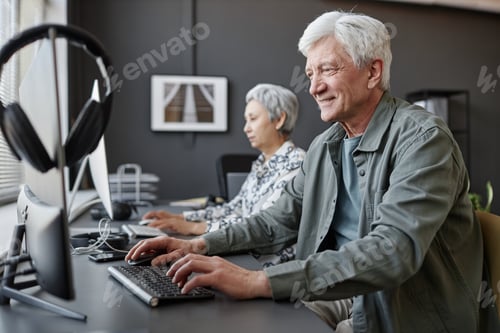 Preview: Smiling senior man using computer in class for elderly people