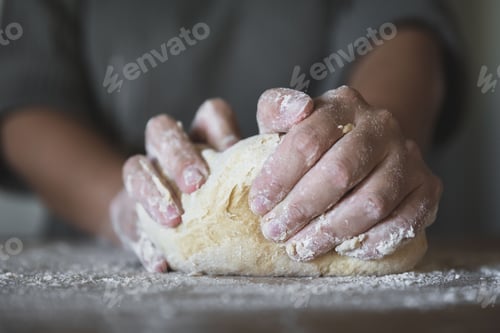 Preview: Closeup shot of a person kneading dough on a kitchen counterto