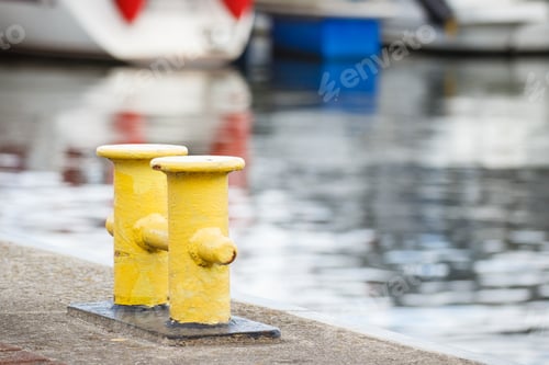 Preview: Yellow bollards on wharf using for anchorage of yachts. Detail of sailboat. Transportation