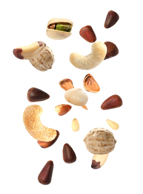 Preview: Different nuts falling on white background