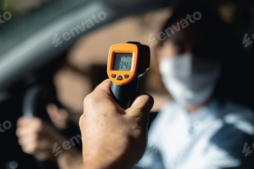 Preview: Caucasian woman sitting in a car wearing coronavirus covid19 mask