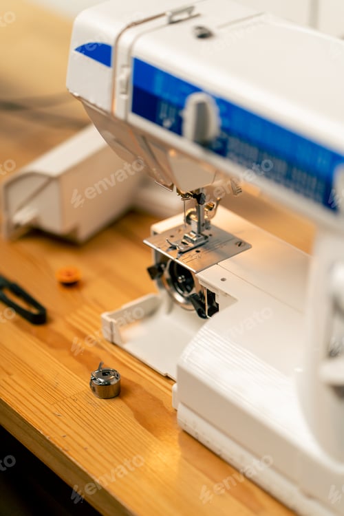 Preview: close-up in a sewing workshop a half-assembled sewing machine tongs and threads