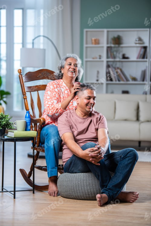 Preview: Indian asian mid aged wife giving head massage to tired husband while sitting at living room