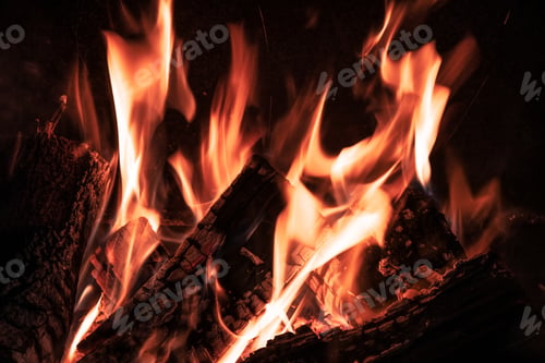 Preview: Fire orange tongues on black background in a brick fireplace
