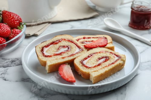 Preview: Tasty cake roll with strawberry jam and cream on white marble table