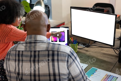 Preview: Rear view of diverse male and female designers discussing at computer with copy space in office