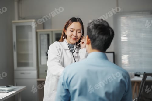 Preview: Female doctor examining patient with stethoscope in hospital