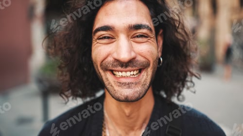 Preview: Young attractive italian guy looks into the camera and smiles at old buildings background
