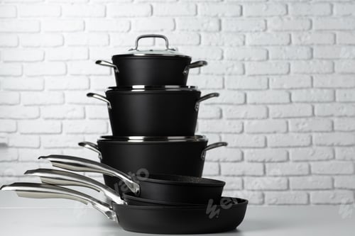 Preview: Set of cookware on table against white brick wall