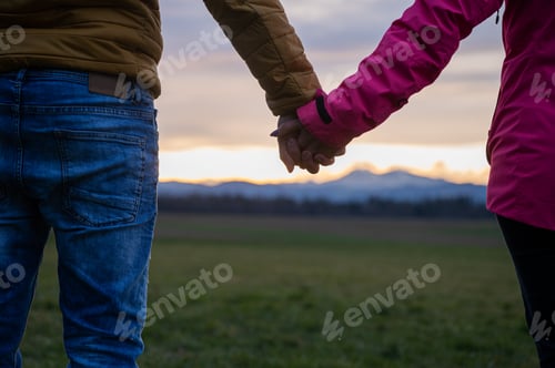 Preview: Closeup view of a couple holding hands standing outside