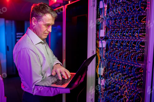 Preview: Mature IT engineer working with server