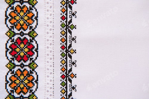 Preview: Texture of linen white fabric with embroidered element. Ukrainian embroidery pattern for folk shirt.