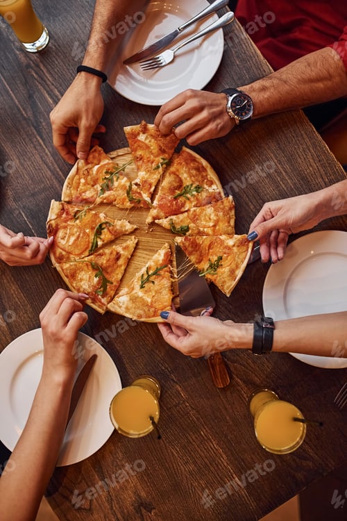 Visualização: Vista de perto de pessoas que comem pizza juntas em ambientes fechados