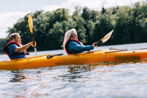 Preview: Happy senior active couple kayaking on lake