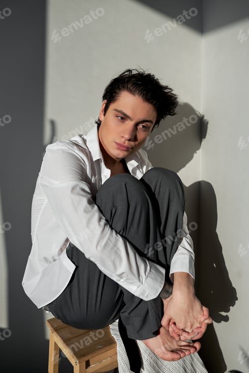 Preview: Sad depressed businessman sitting, hugging knees dramatic concept
