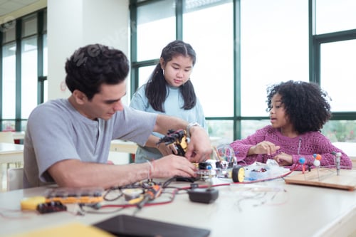 Preview: A teacher guiding students in a robotics project during a STEM class in the library
