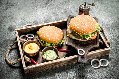 Preview: Fresh burgers with beef and vegetables on an old tray.