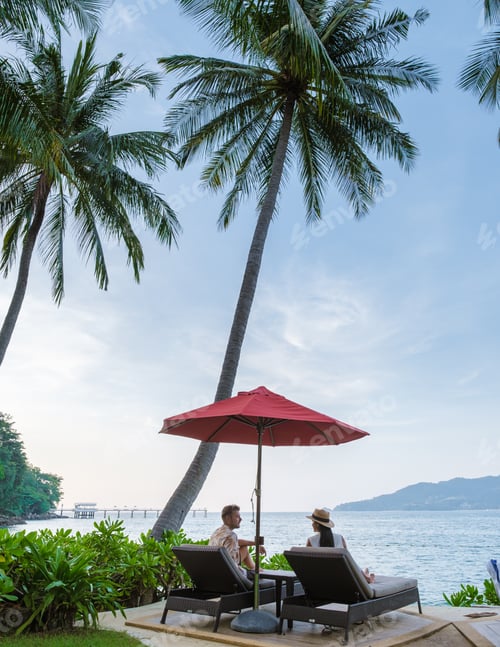 Preview: couple in sunbed watching sunset over the bay of Patong Phuket Thailand