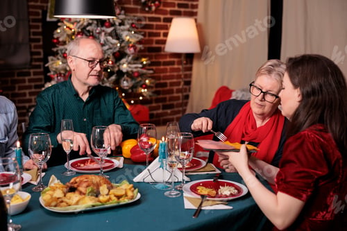 Preview: Family having christmas festive dinner, passing plate with dish