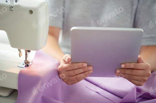 Preview: tailor with sewing machine, tablet pc and fabric