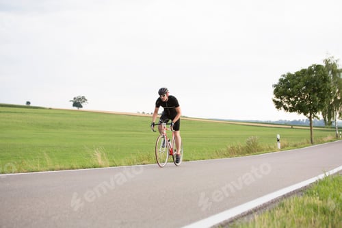 Preview: Mature man cycling along country road