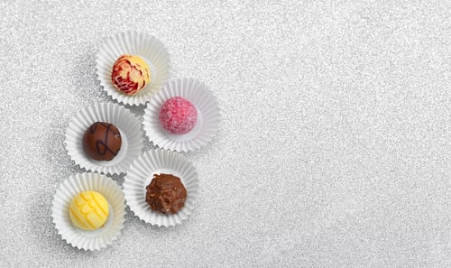 Preview: Chocolate candy assortment arranged in circle composition on light background.