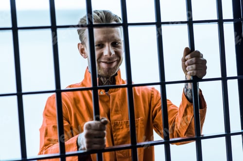 Preview: smiling prisoner holding prison bars
