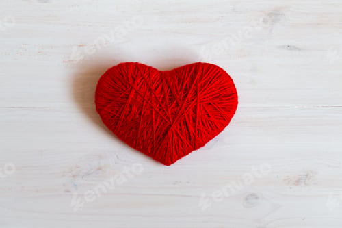 Preview: Red heart shape made from wool on white wooden background