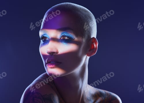 Preview: Studio shot of an attractive young woman wearing edgy makeup against a blue background