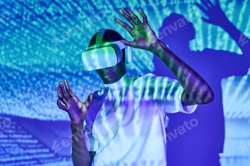 Preview: Concentrated black man touching air while experiencing virtual reality