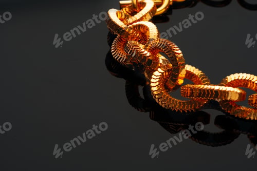 Preview: Golden chain necklace on black background with reflection