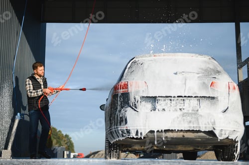 Preview: Car is washed at a professional car wash. Man washes a car with foam. Detailing