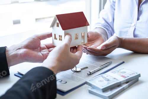 Preview: Estate agent giving house and keys to client after signing agreement contract real estate with