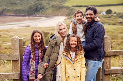 Preview: Portrait Of Active Multi-Cultural Family Standing By Gate On Winter Beach Vacation