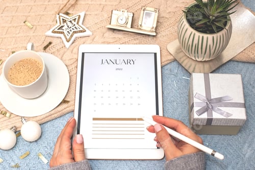 Preview: Digital tablet with a calendar for January, in the hands of a girl