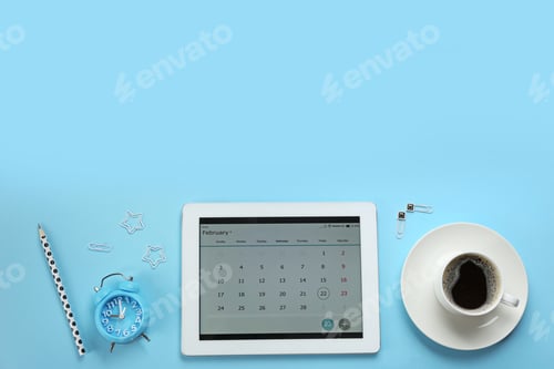 Preview: Modern tablet with calendar app on light blue background, flat lay. Space for text
