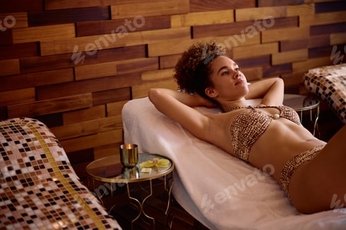 Preview: Young woman day dreaming while relaxing at the spa.