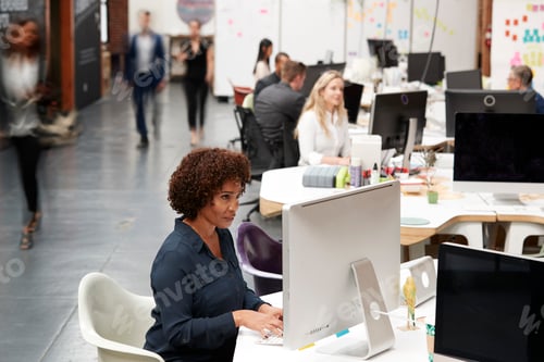 Visualização: Equipe de negócios trabalhando em mesas em um escritório moderno de plano aberto