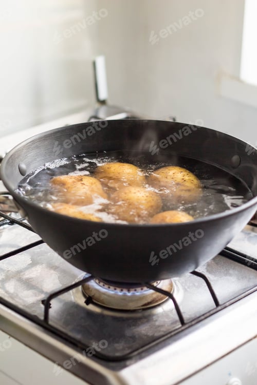 Preview: Potatoes boiling in a saucepan on a gas hob