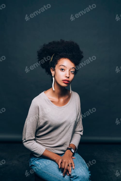 Preview: Young woman with natural hair posing against a dark backdrop
