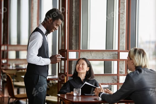 Preview: Black young man as server taking orders from couple