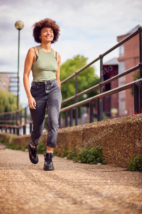 Preview: Smiling Young Woman Outdoors Laughing As She Walks Through City