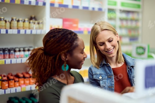 Preview: Two Women Smiling Together While Shopping in a Colorful Pharmacy Store
