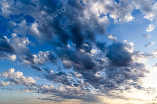 Preview: Beautiful white puffy clouds against blue sky during dramatic sunset