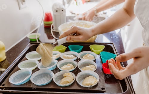 Preview: Family cooking at home. Young girl making homemade cupcakes at home kitchen.