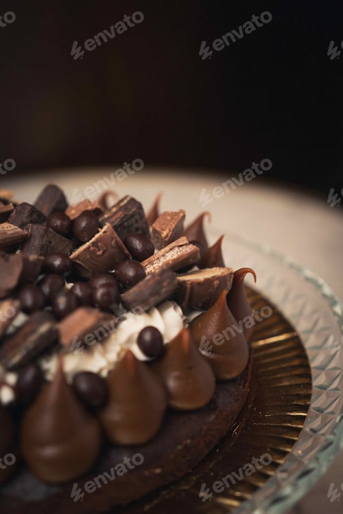 Visualização: Foto vertical de um saboroso bolo de chocolate em um prato de vidro sobre uma mesa