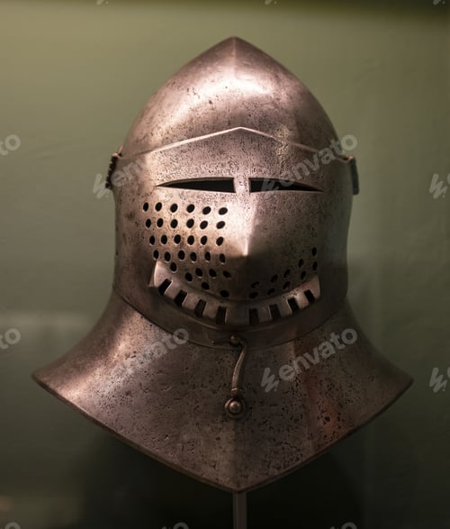 Preview: Closeup of a medieval metal war helmet under the lights in a museum