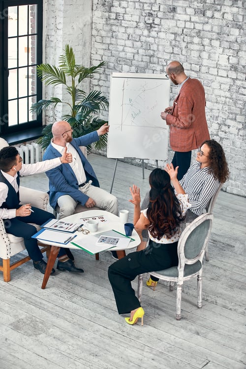 Preview: Confident businessman writing on flip charts presentation new project in boardroom at company