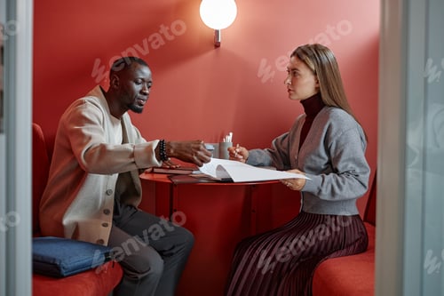 Preview: Female Employee Signing Job Agreement at Job Interview with Male Recruiter in Coworking Space
