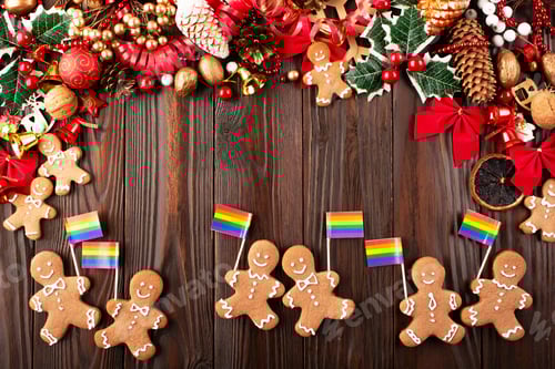 Preview: Christmas background of gingerbread cookie men with rainbow flags on wooden table
